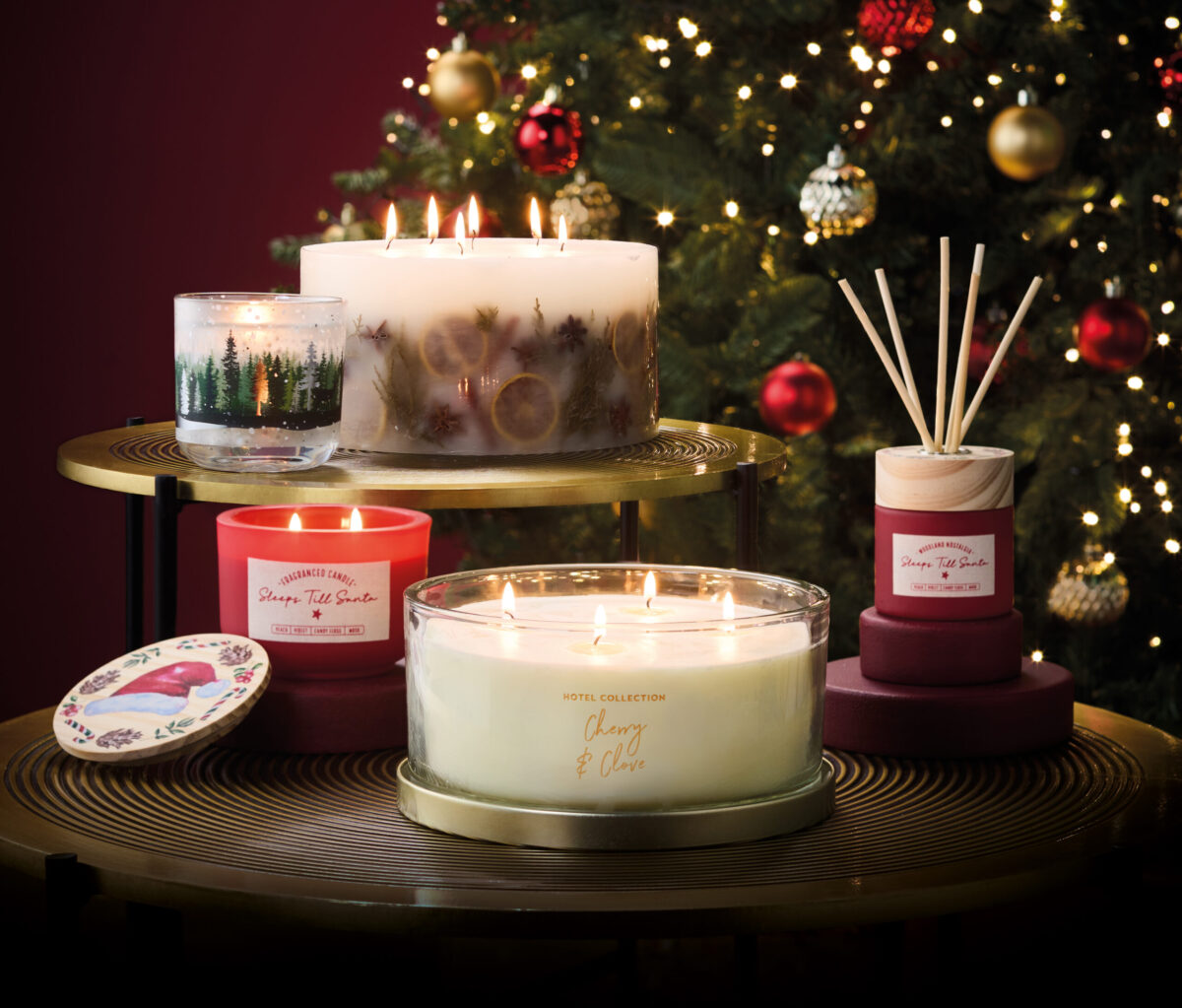 a collection of Aldi's Christmas candles in front of a Christmas tree